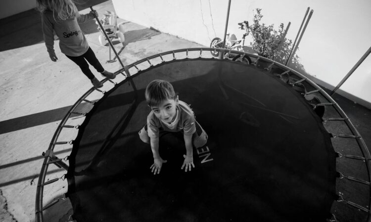 Kind op de trampoline in zwart wit