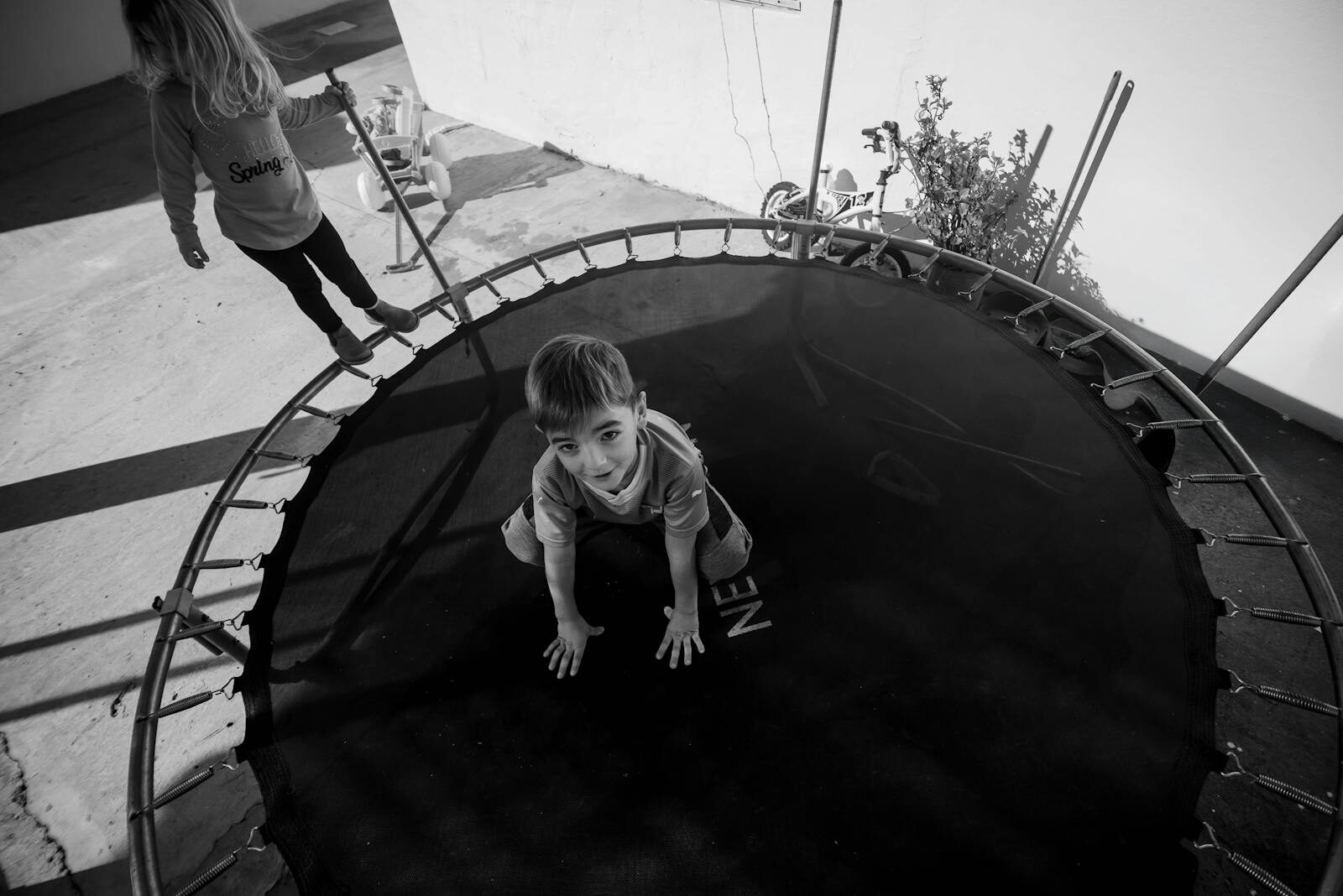Kind op de trampoline in zwart wit