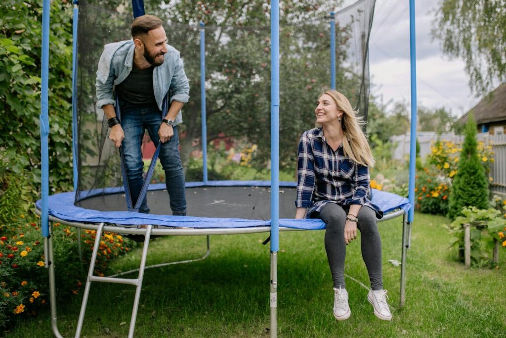 Twee volwassenen op een trampoline