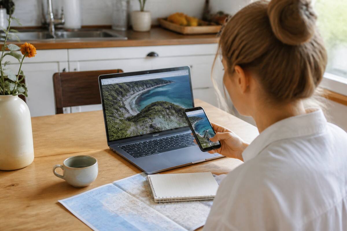 Reiziger vergelijkt vakantieopties op laptop en smartphone